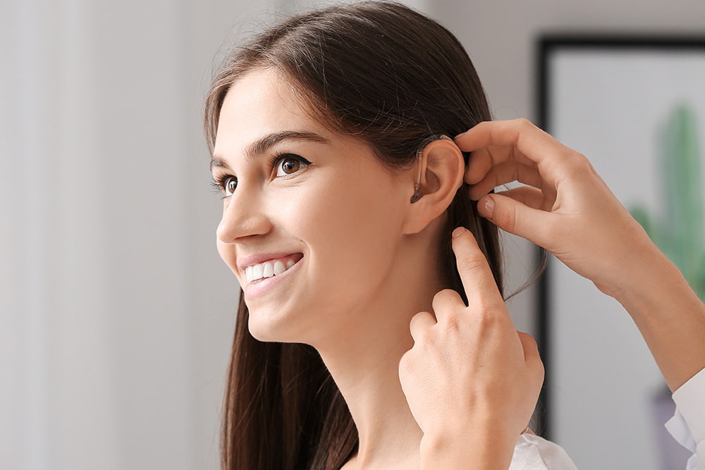 a young woman getting a hearing aid